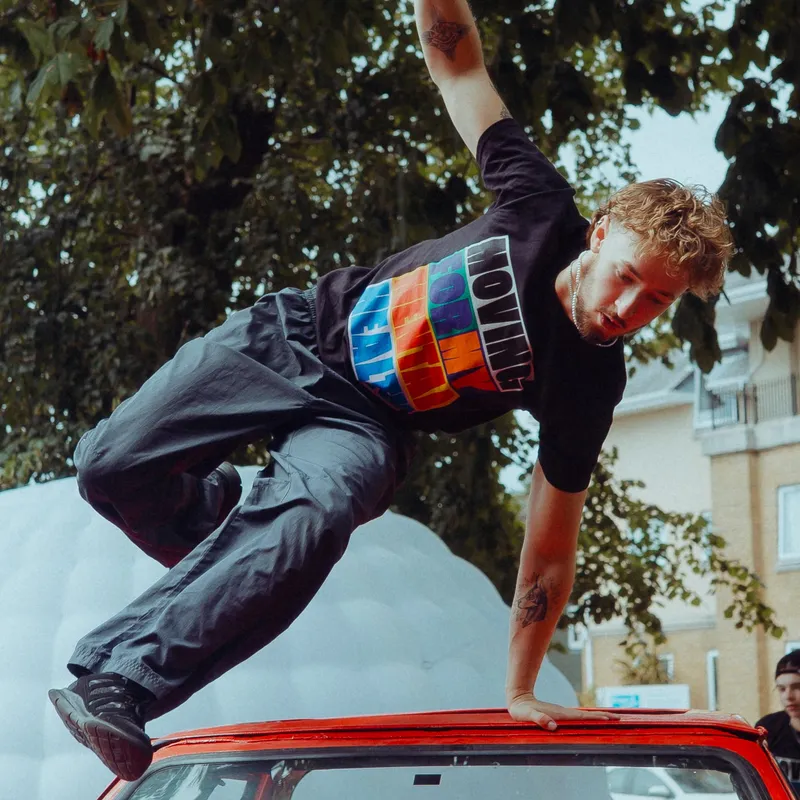 A young dancer jumps wearing a t-shirt for The Big Movement